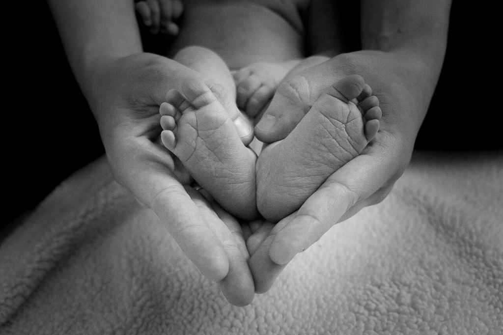 baby's feet in mother's hands